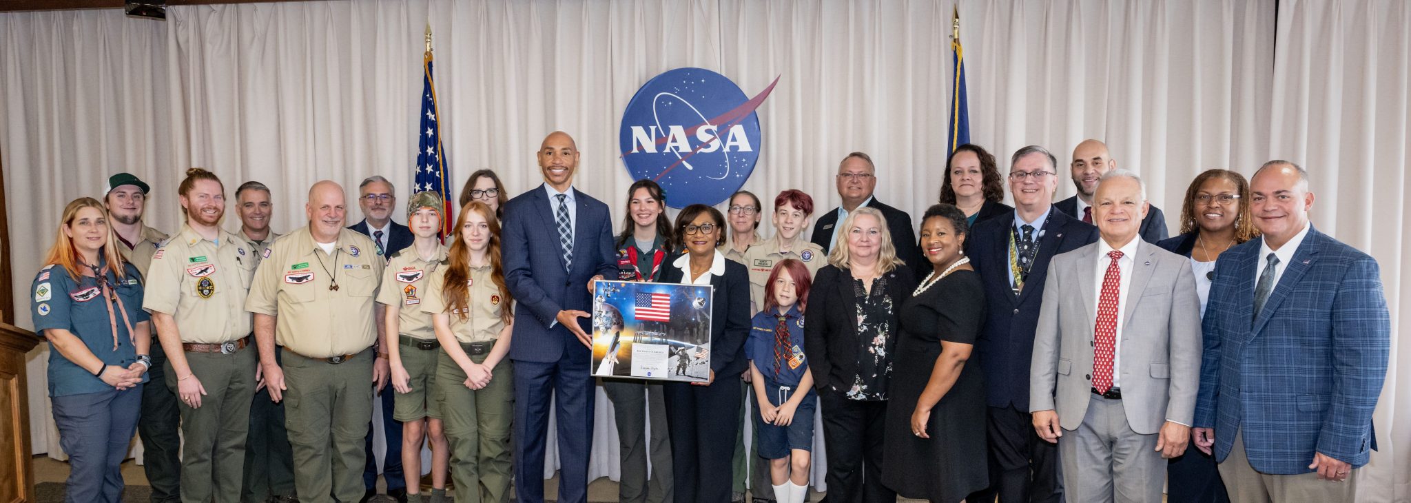 Johnson Space Center directors present a framed honorarium with a space-flown American flag to Scouting America team members.