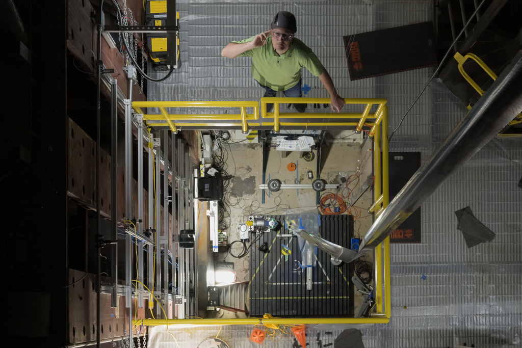 Researchers conducted the tests inside a 100-foot tower at NASA Langley. A researcher is visible here looking up at the boom from a platform in the tower.