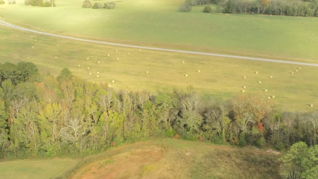 An aerial view at Redstone Arsenal in Huntsville, Alabama. The green field contains hay bails and trees.
