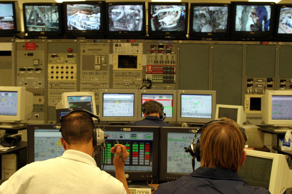 Test Control Center operators are seated at a workstation to monitor post-test activities