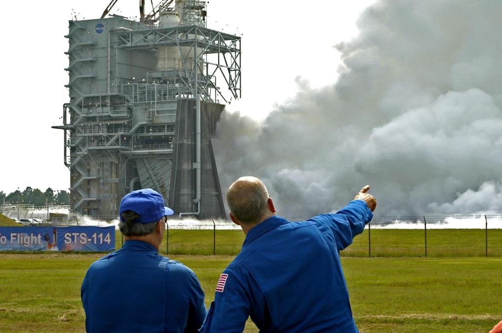 NASA astronauts Jerry Ross, left, and Alan Poindexter view a space shuttle main engine test