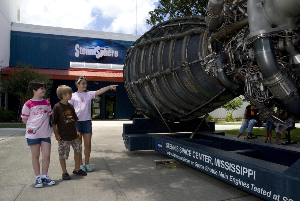 Young visitors enjoy an up-close view of a space shuttle main engine outside the StenniSphere Museum