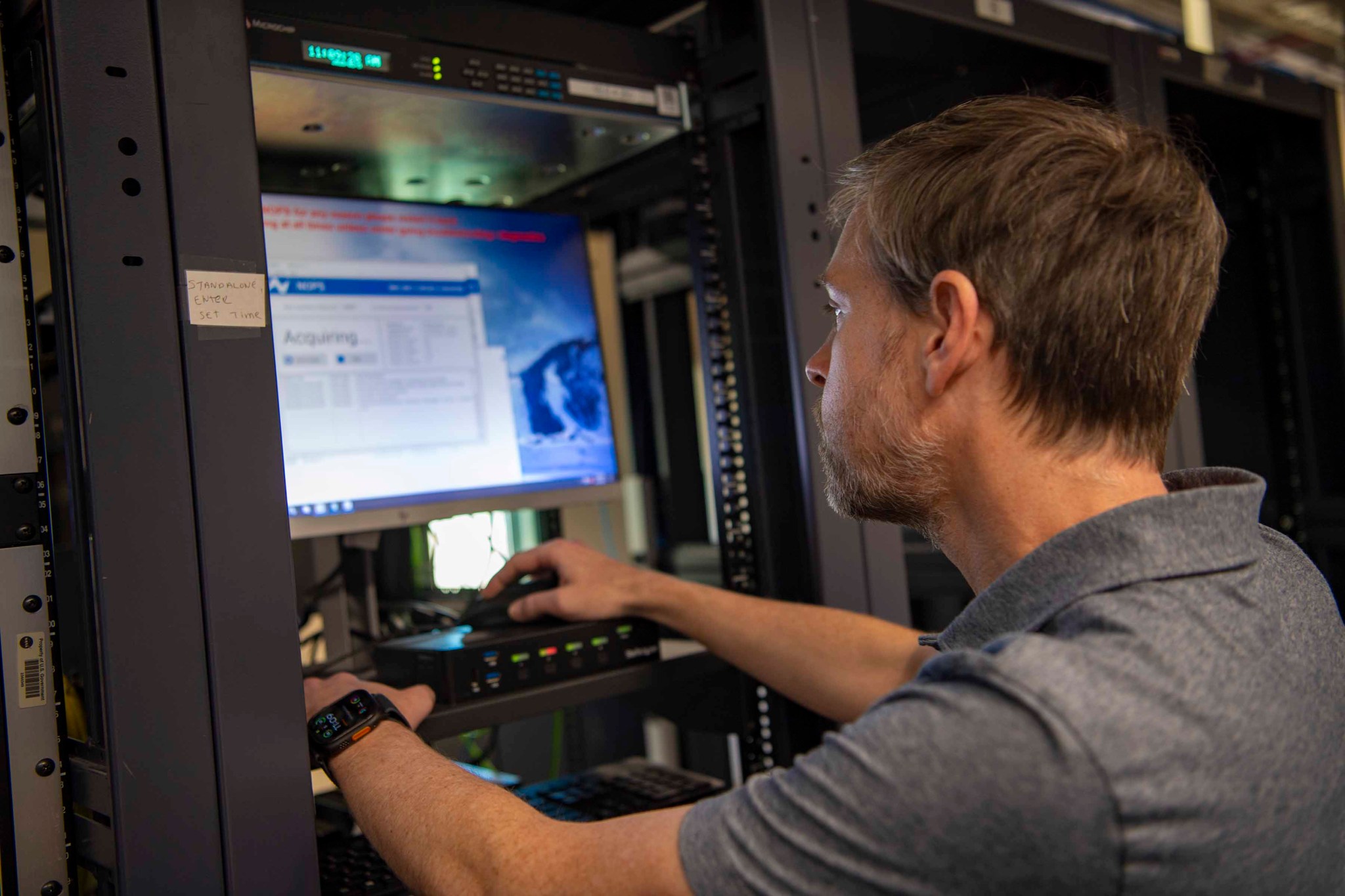 Syncom Space Services software engineer Shane Cravens stands at a workstation