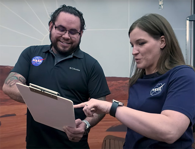 Mars Exploration Simulation Manager Daniel Hernandez holds a clipboard inside the CHAPEA habitat