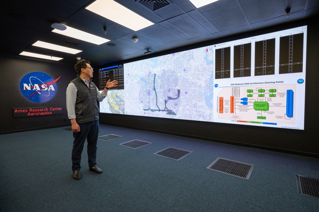 A NASA researcher presents information on a large screen.