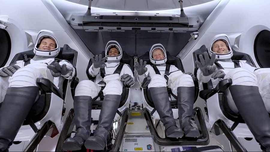 (From left) Ax-4 Mission Specialist Tibor Kapu, Pilot Shubhanshu Shukla, Commander Peggy Whitson, and Mission Specialist Sławosz Uznański-Wiśniewski wave from inside the Space Dragon spacecraft.