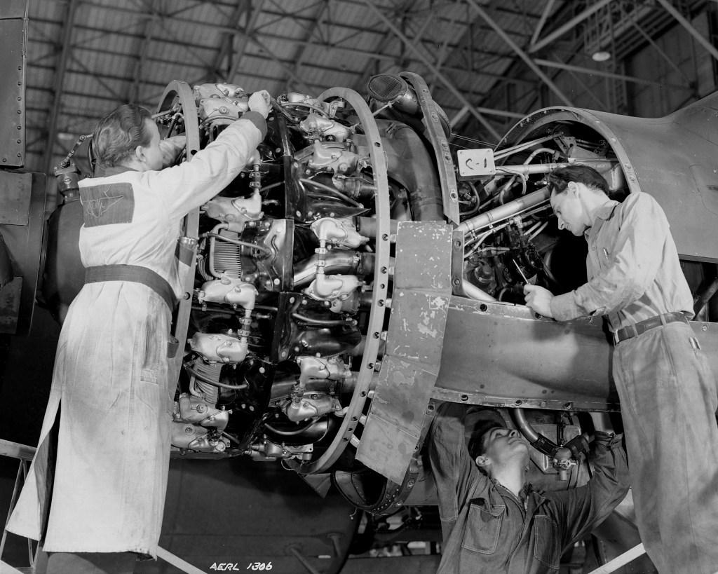 Three Mechanics work on a piston engine in the hangar