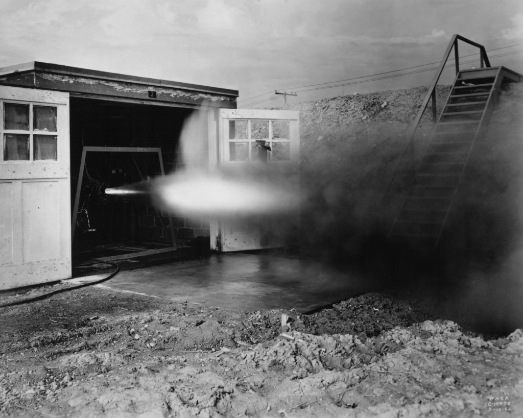 Rocket firing horizontally out of test cell.