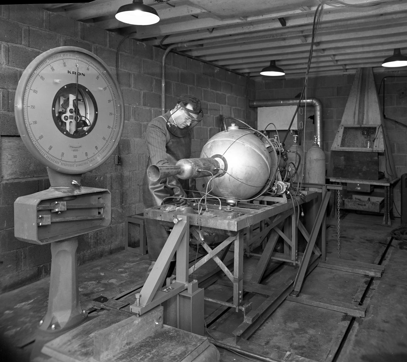 Man with small engine in test cell.