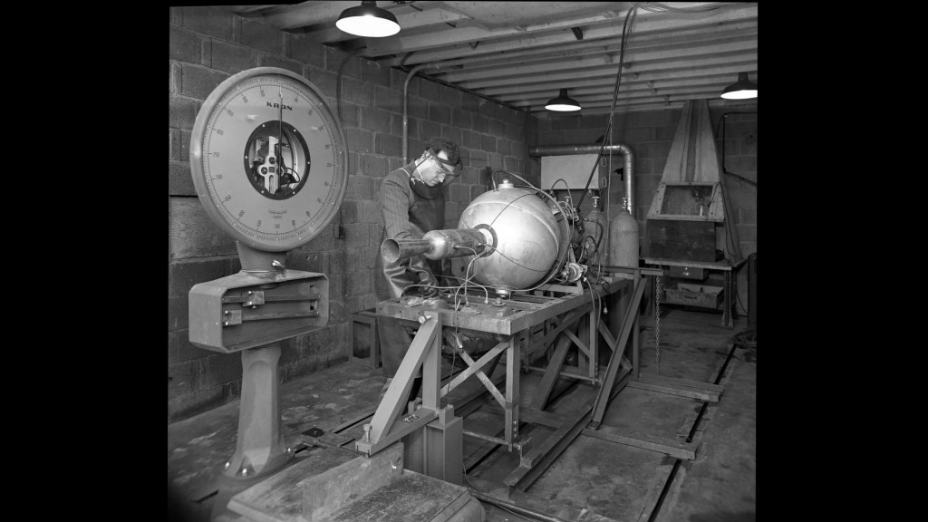 Man with small engine in test cell.