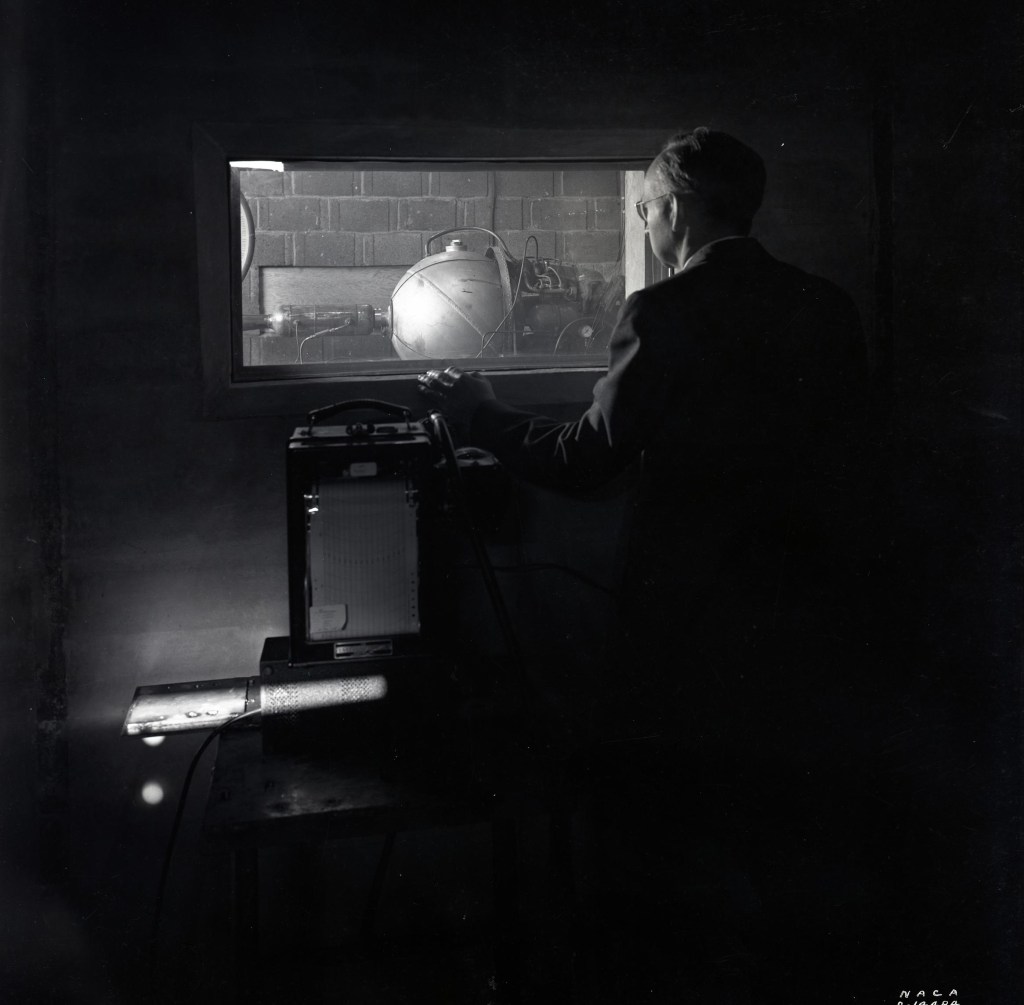 Man looking through window at test cell.