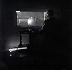 Man looking through window at test cell.