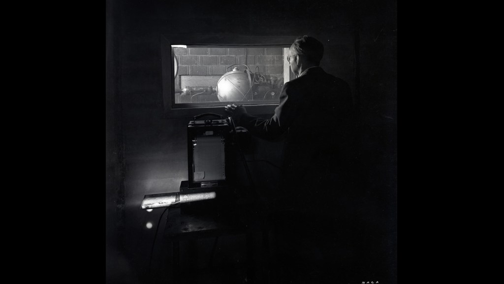 Man looking through window at test cell.