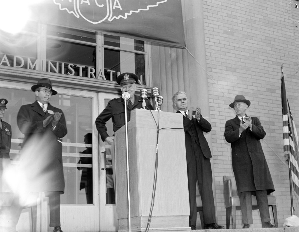 Man at podium outside building.