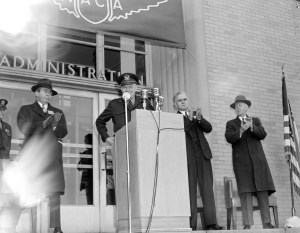 Man at podium outside building.