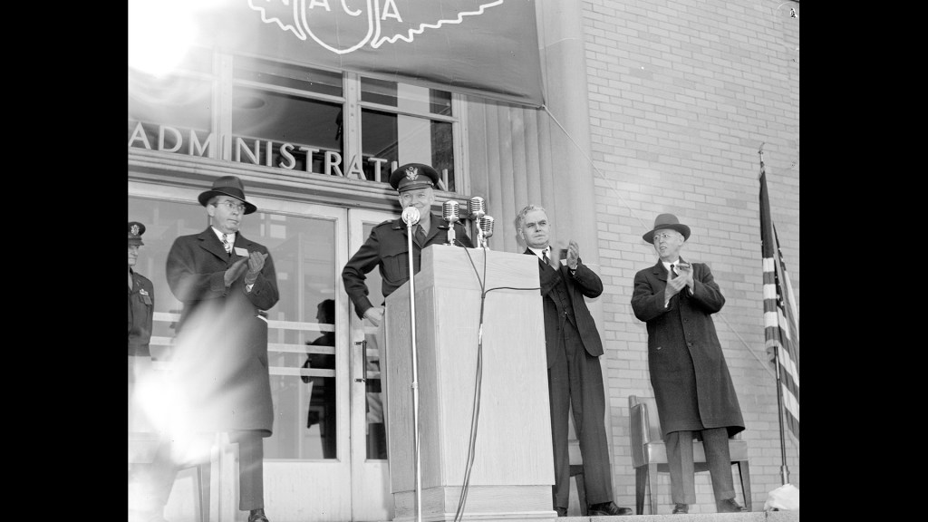 Man at podium outside building.