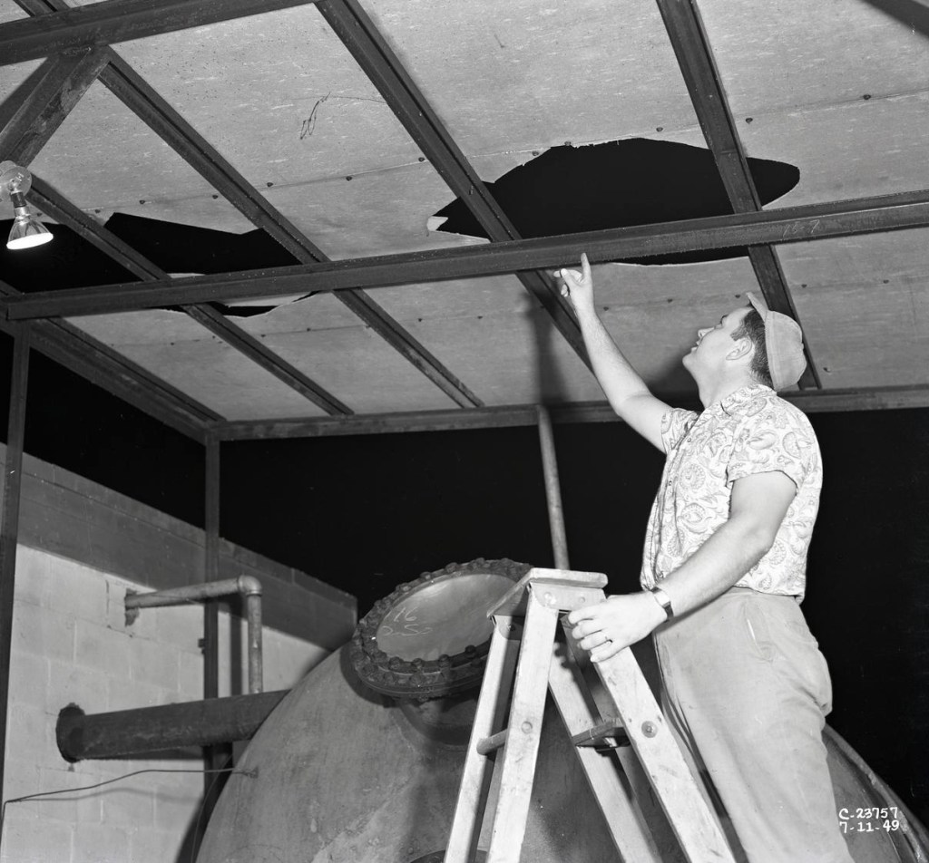 Man on later viewing hole in ceiling.