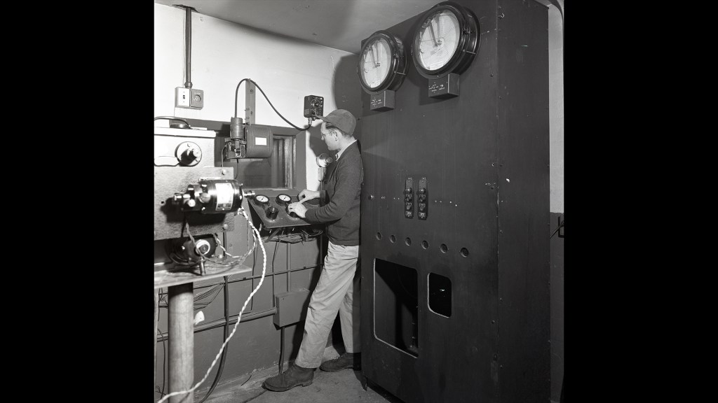 Man with small engine in test cell.