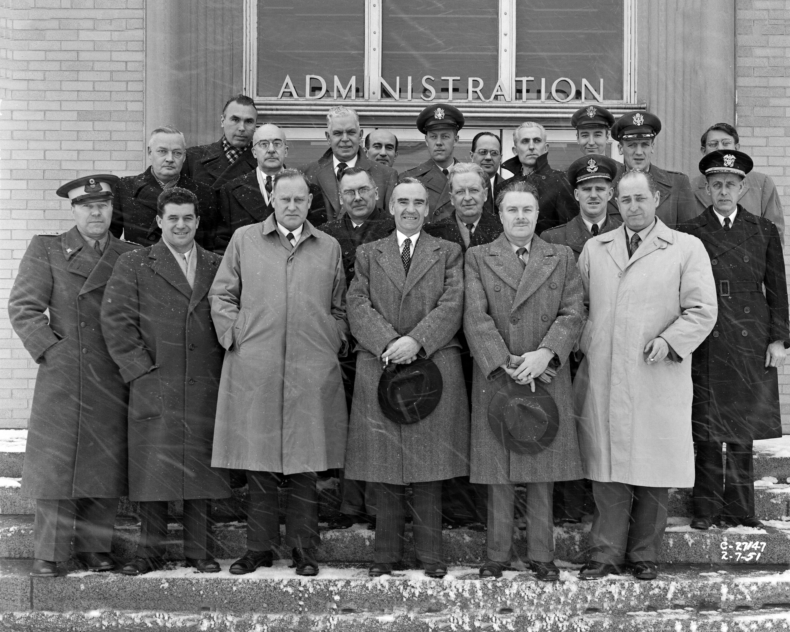 Group of men posing for photo on building steps.