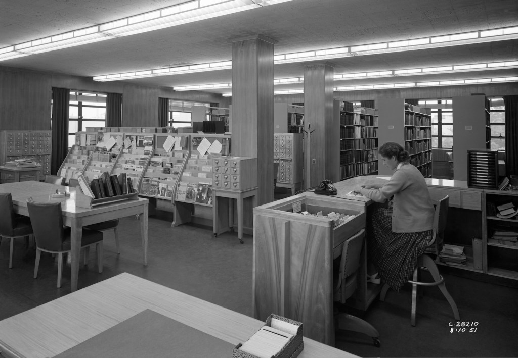 Librarian at desk in library.