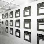 Man looking at data recorders on wall.