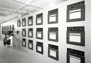 Man looking at data recorders on wall.