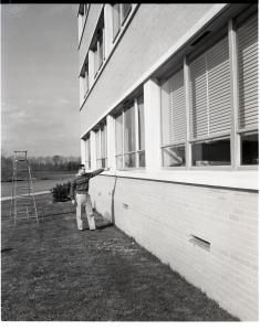 Man looking at broken windows.