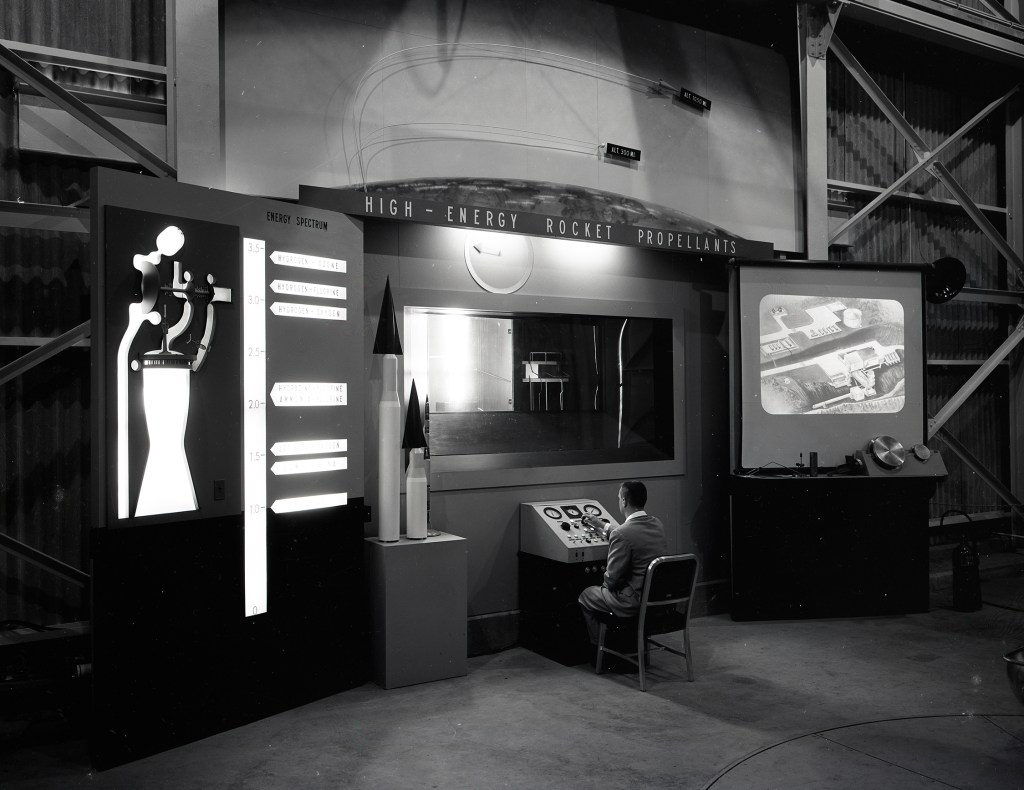 Man seated at control panel at RETF display.