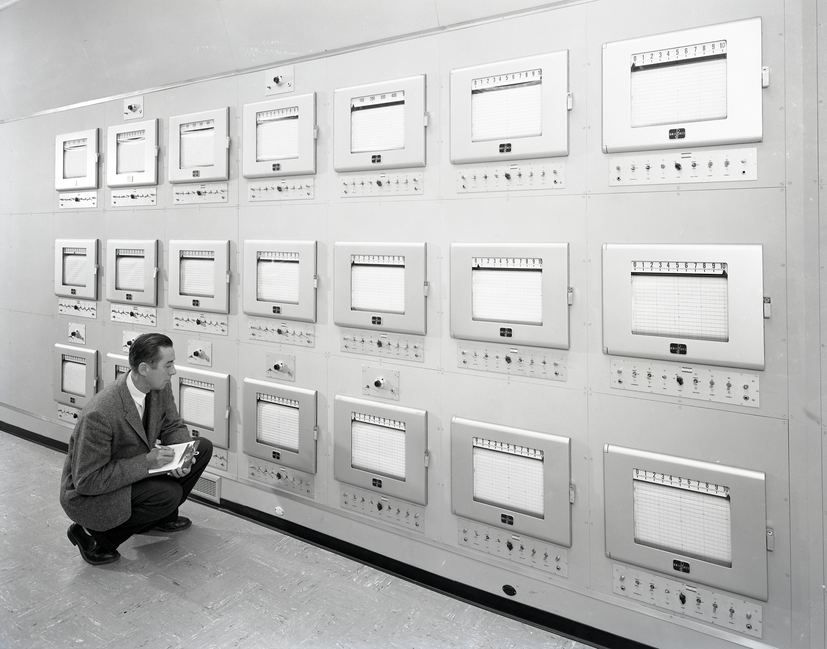 Engineer kneeling and reading charts