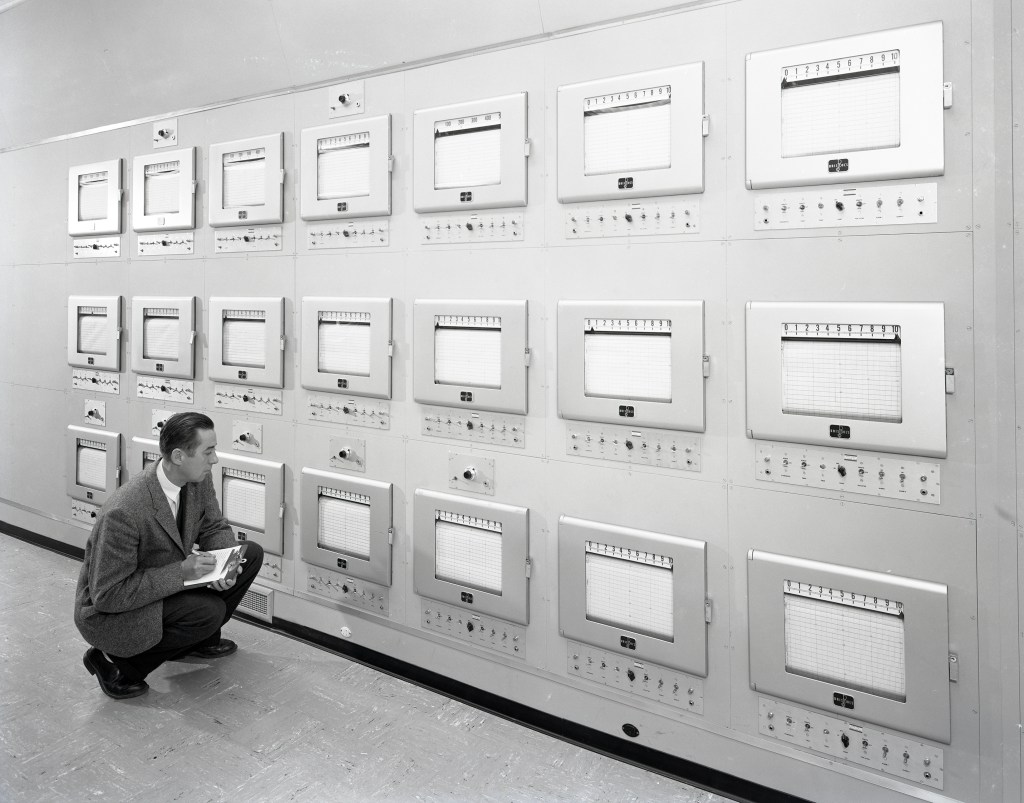 Engineer kneeling and reading charts