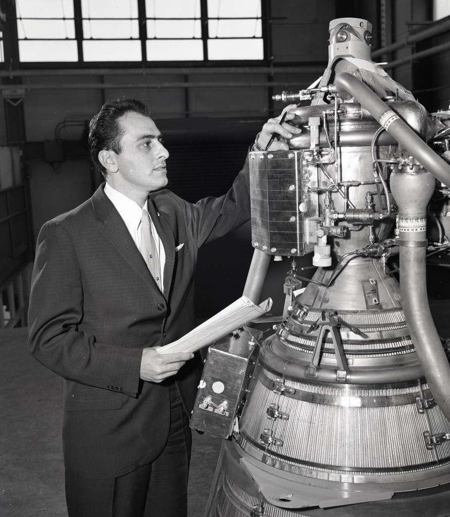 Man viewing small rocket engine.