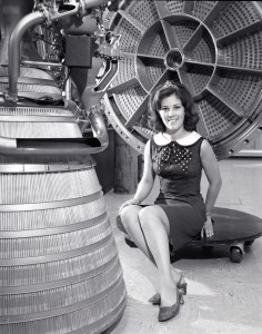 Woman poses with rocket engine.