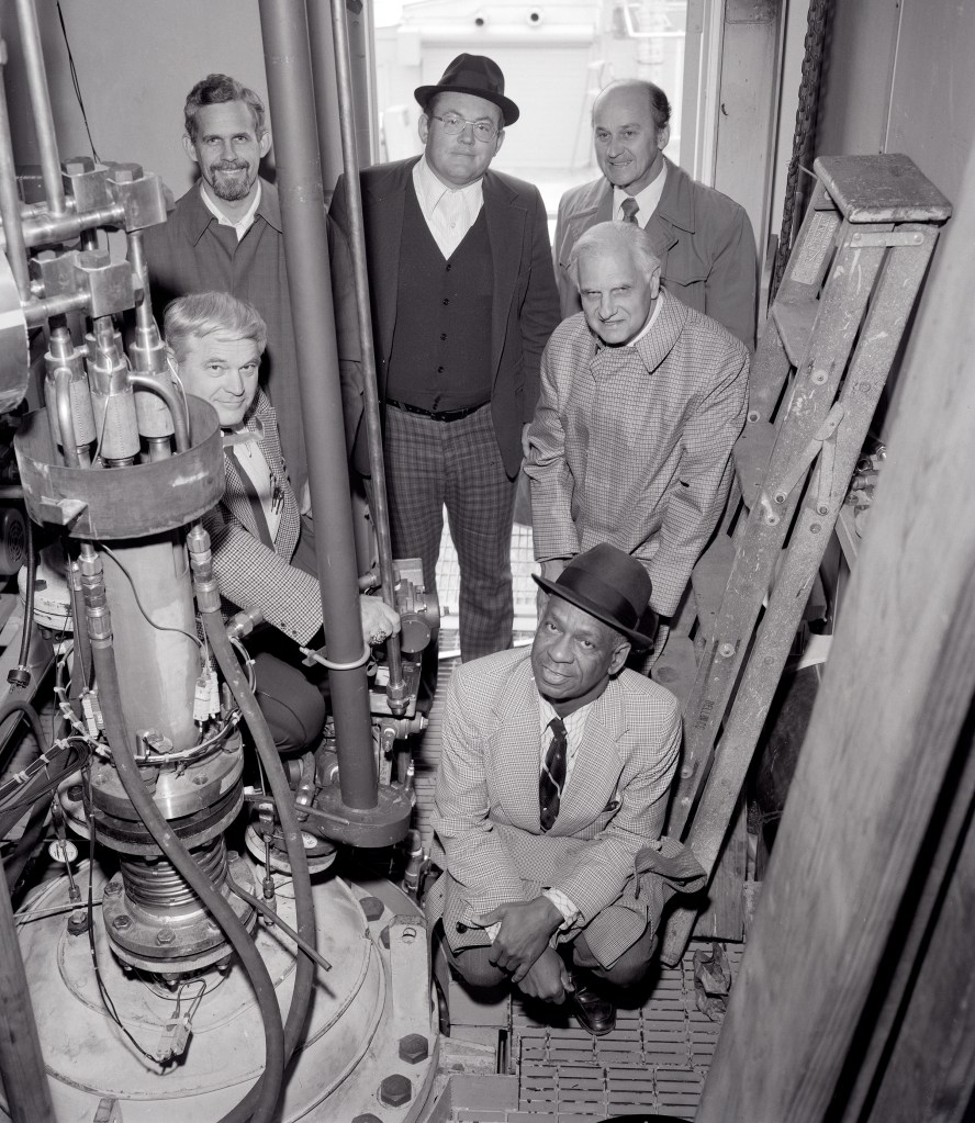 Men crowded in small test cell.