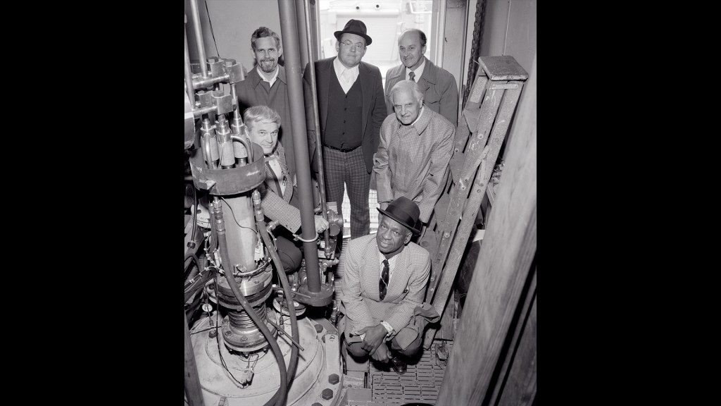 Men crowded in small test cell.