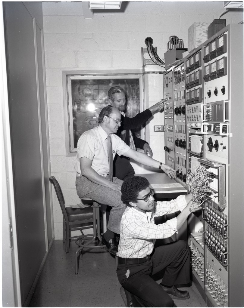 Men in small control room.