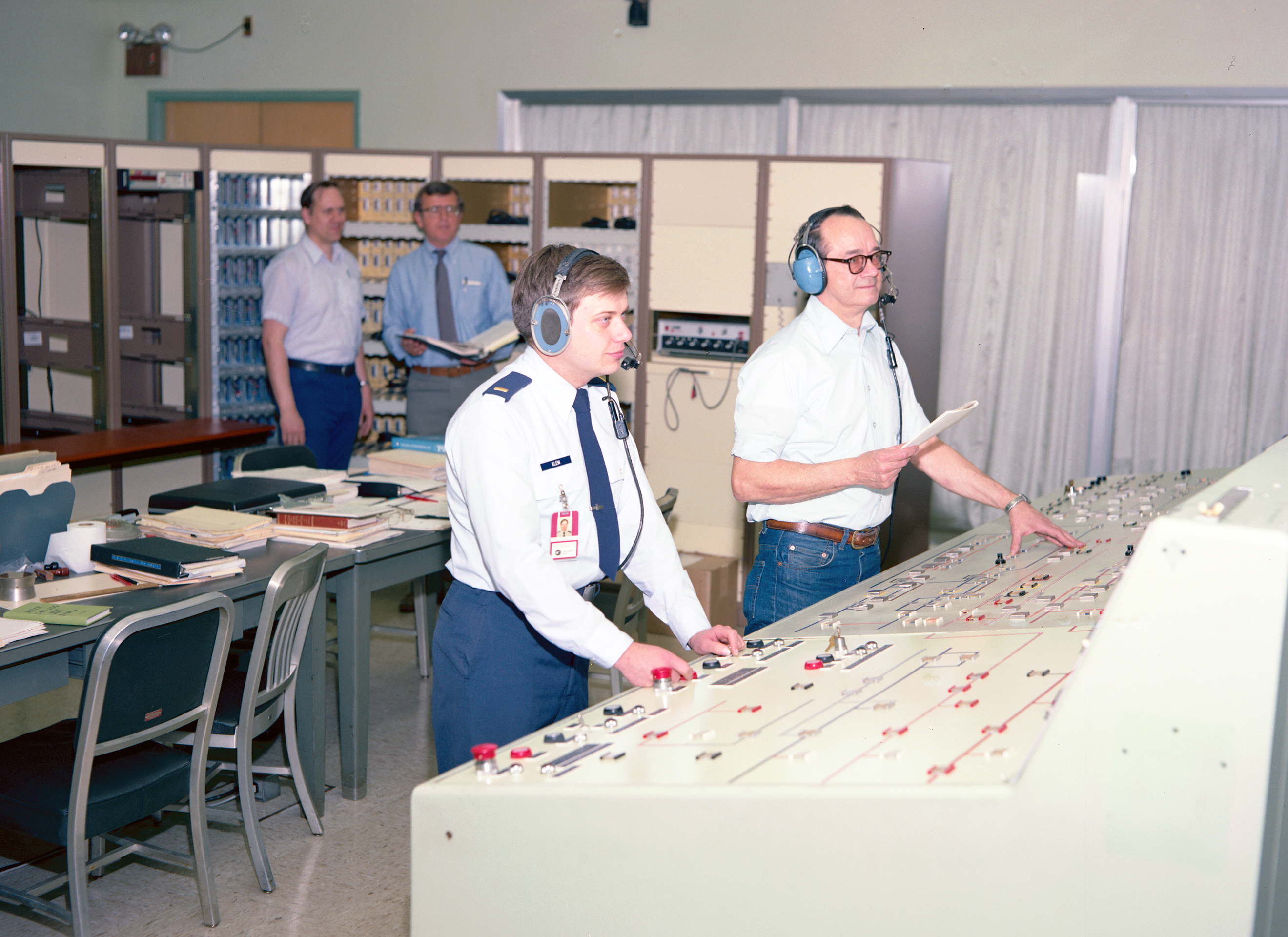 Four men in control room conducting test
