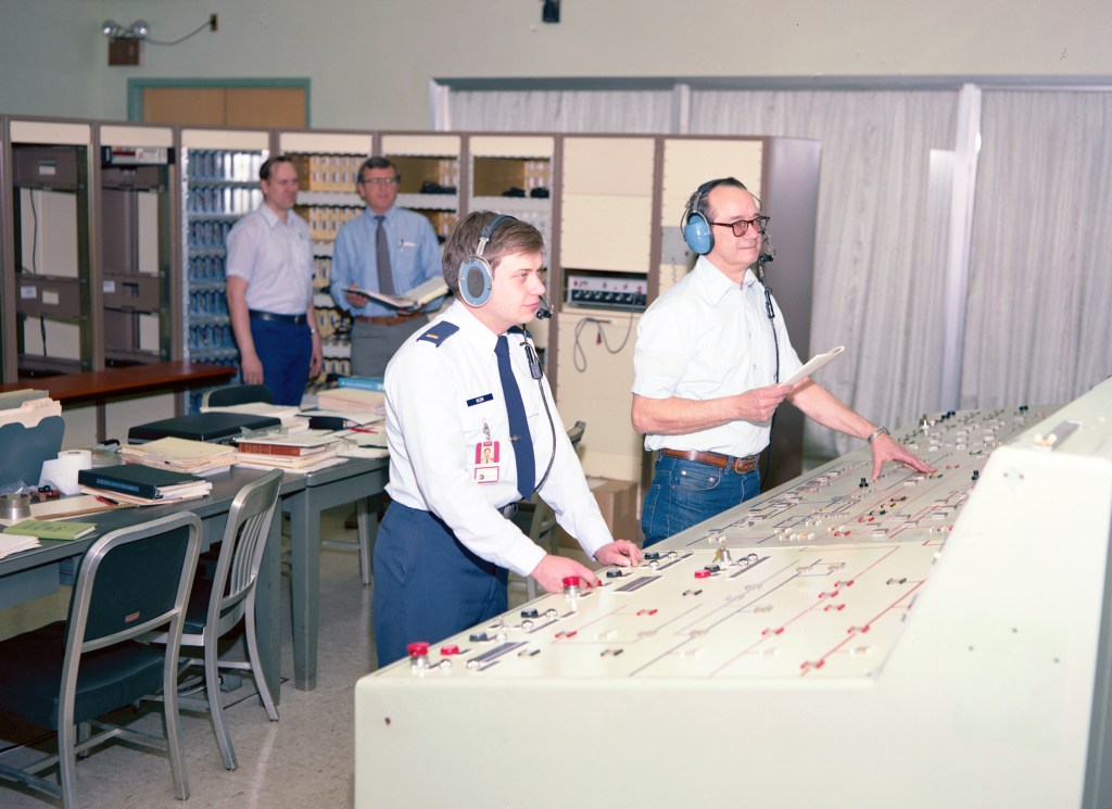 Four men in control room conducting test