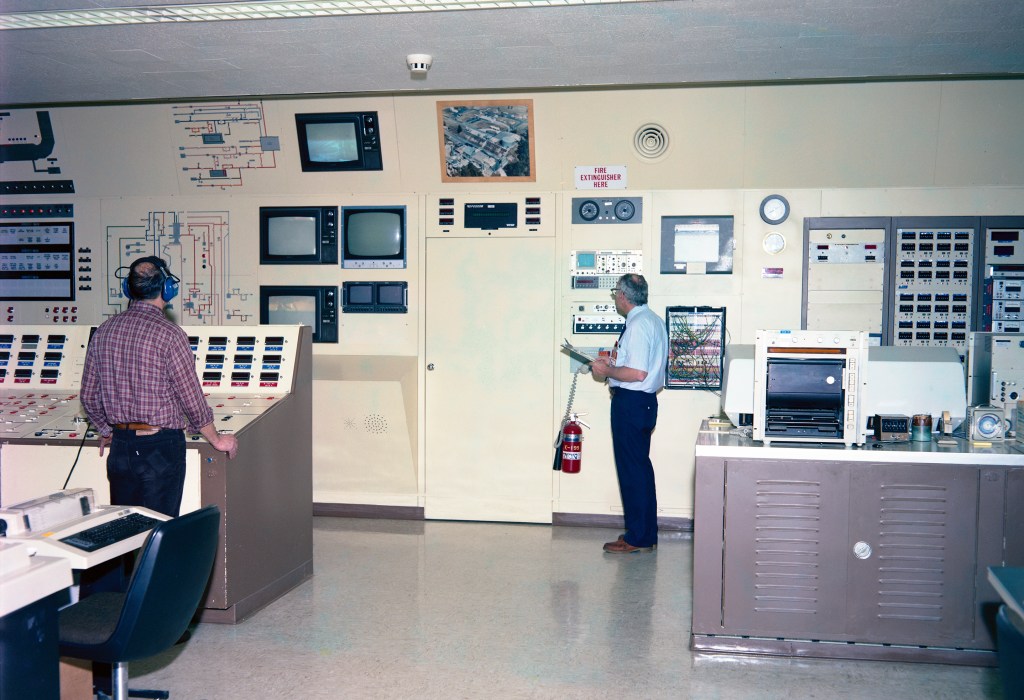 RETF control room showing system schematic, television monitors, and control panels (1987).