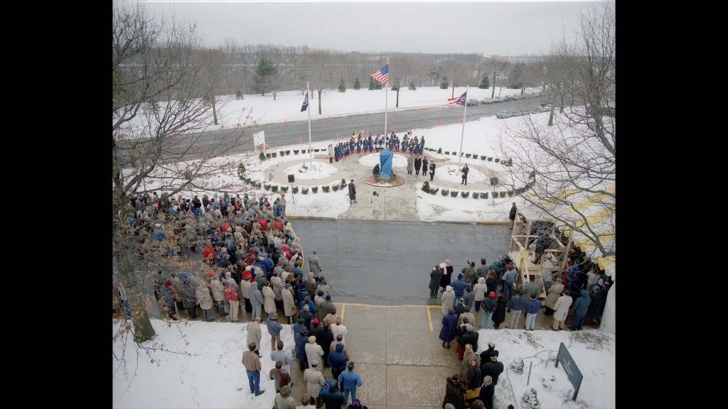 Group around flagpole in the snow.