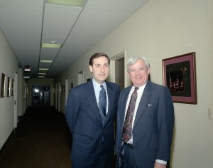 Two men standing in hallway.