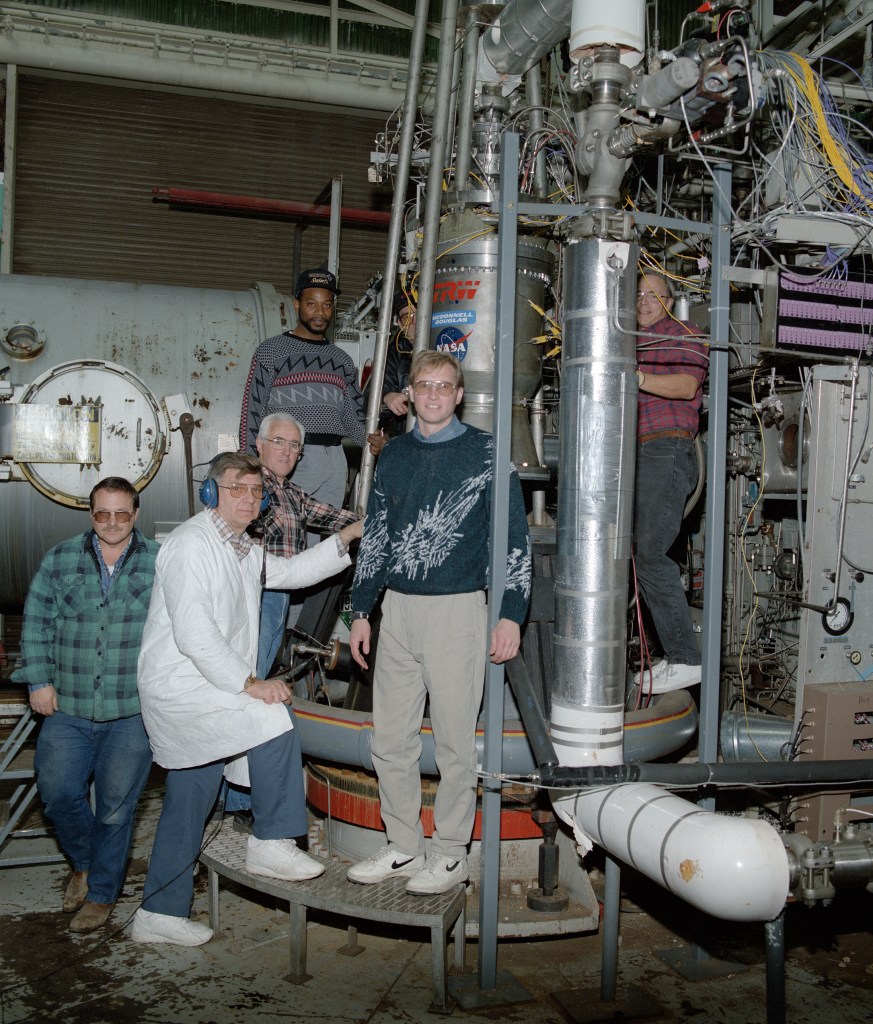 RETF staff with engine in test stand