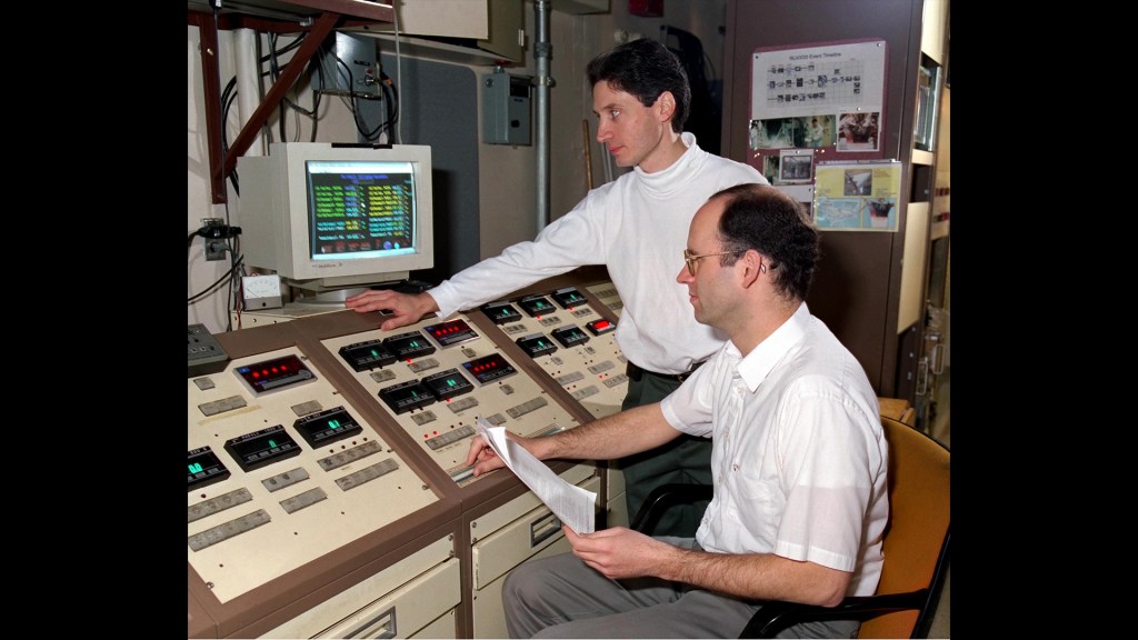Two men in control room.