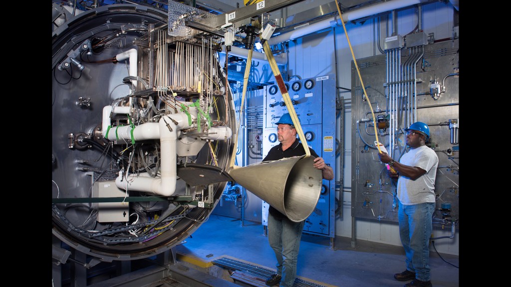 Technicians install engine on test stand.