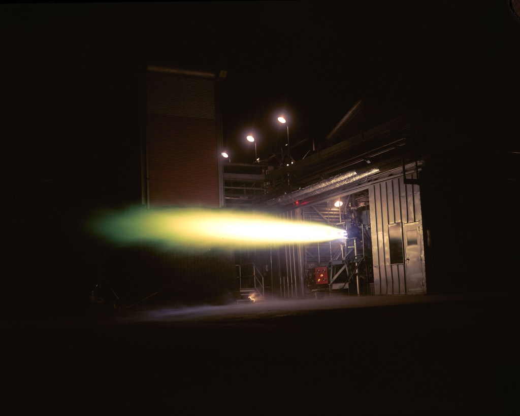 Rocket firing horizontally out of test cell.
