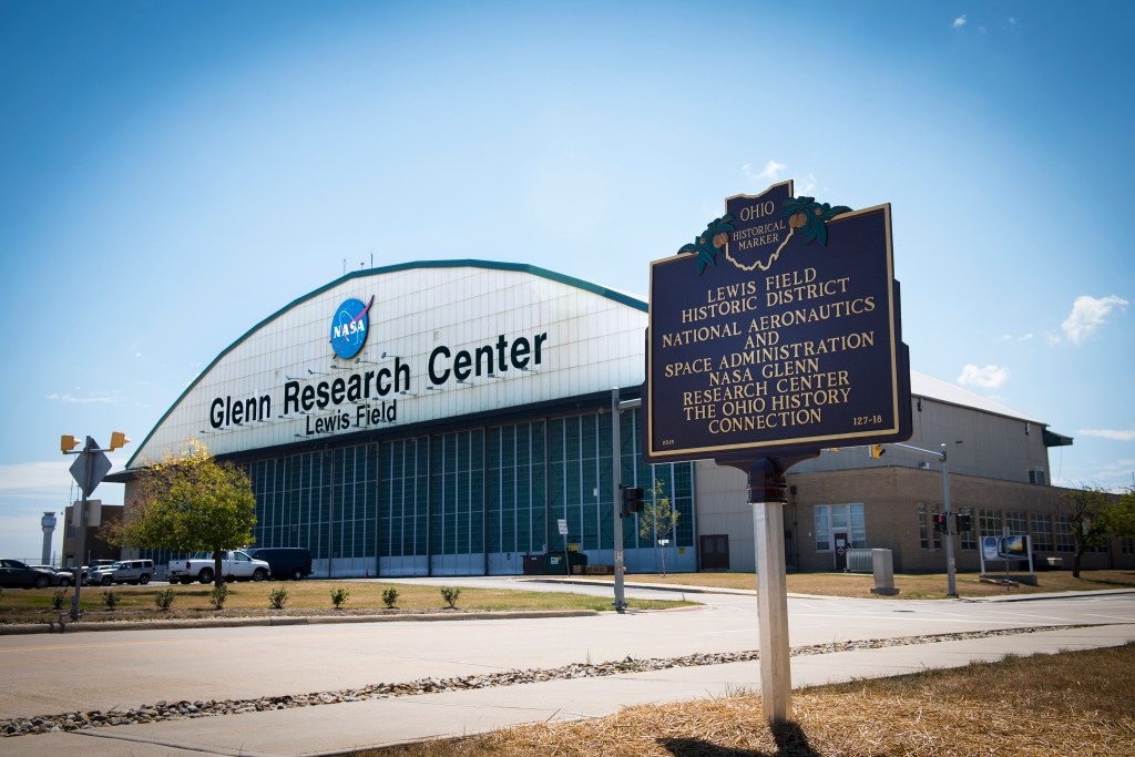 Historic marker with hangar in background.