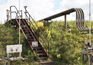 Rusting stairs over grassy mound.