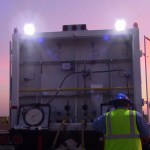 Person looking at a balloon payload at sunrise.