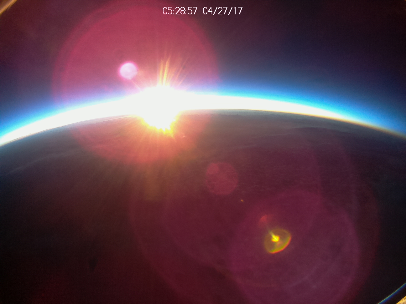 An image of the Sun rising over Earth taken form above the atmosphere.