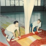 Two employees unrolling and testing balloon materials.