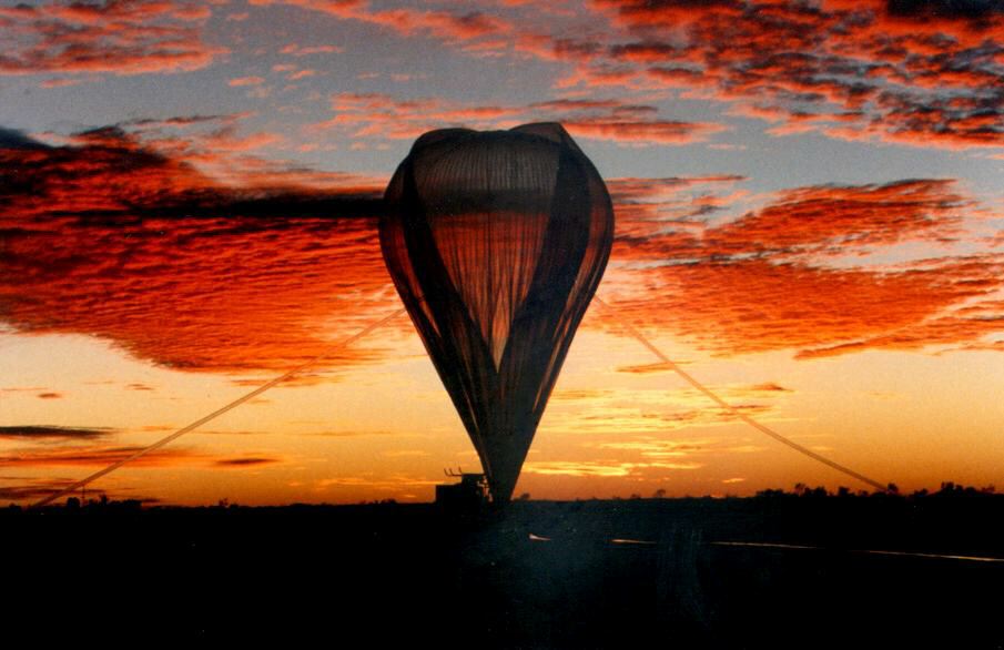 Balloon being inflated in front of sunset.